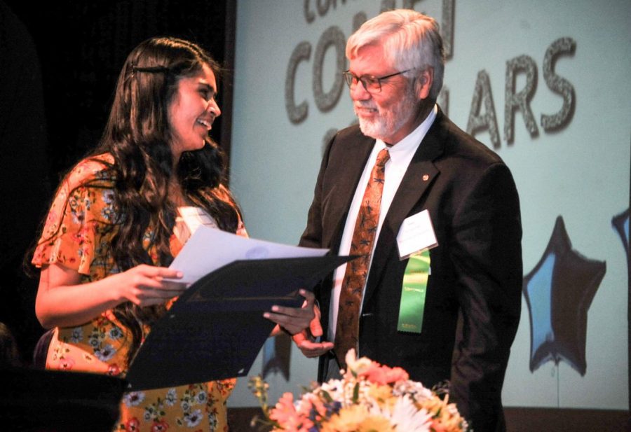 Josielyn Bustamante (left) receives a scholarship certificate from Foundation Secretary William van Dyk during the Scholarship Awards Ceremony in the Knox Center on May 2.