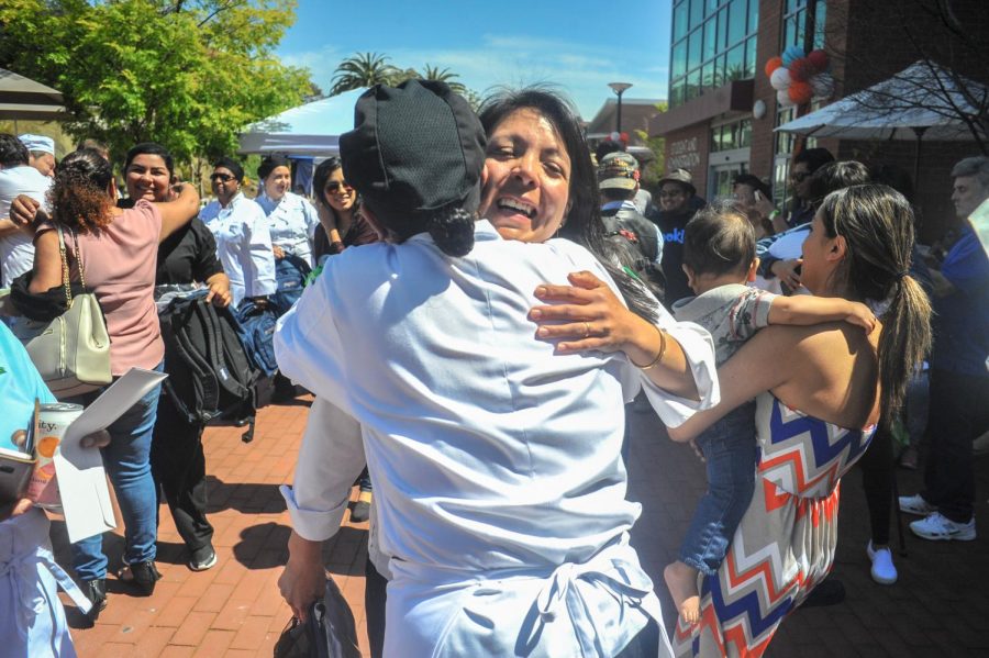 Culinary arts students hug each other after the announcement at the Food and Wine Event in the Campus Center Plaza of the seven students going to Italy. Every summer culinary arts students travel abroad to learn about Italian cuisine.  