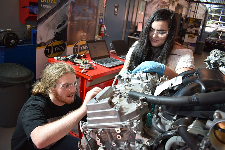 Automotive students Craig Yano and Mariah Henry work together to take apart a V6 Toyota engine in the Automotive Technology Building on Thursday. A number of engines were given to the automotive department by Toyota as part of the upcoming T-Ten program.