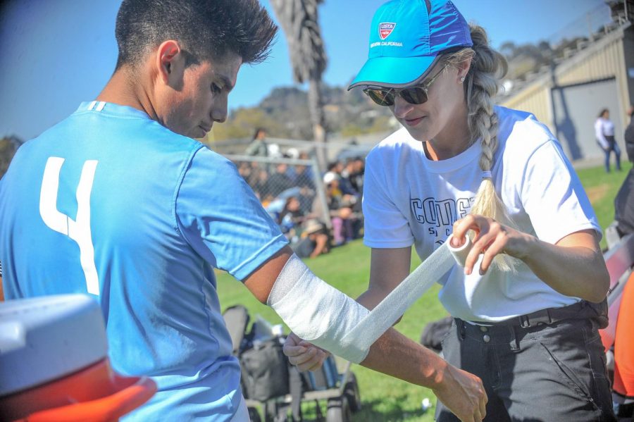New athletic trainer Nichole Oaks wraps a bandage around Comet men’s soccer team defender Raul Garcia’s arm during a home game on Friday against College of the Redwoods.