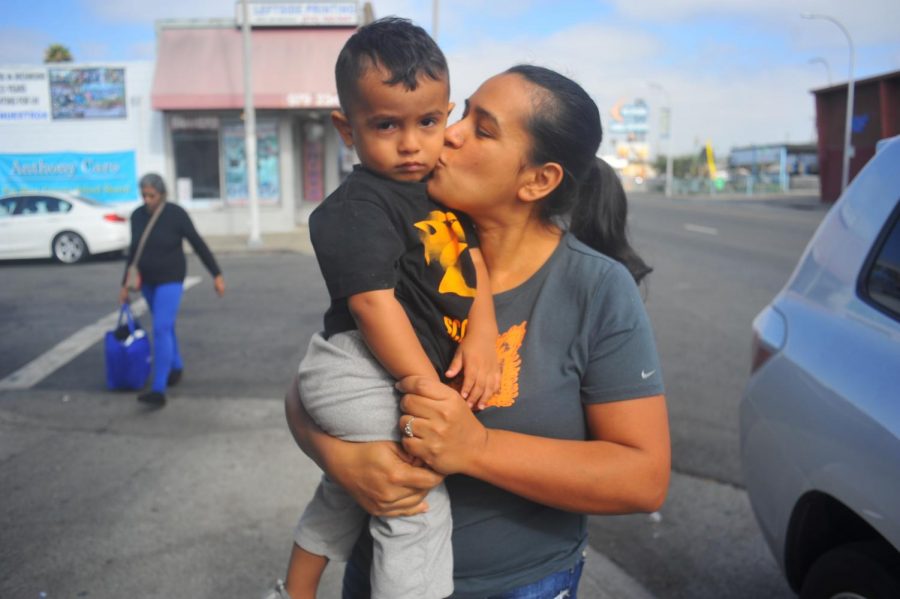 Guadalupe Mendoza kisses her son, Joshua Mendoza as she walks down 23rd Street in Richmond, California on Monday.