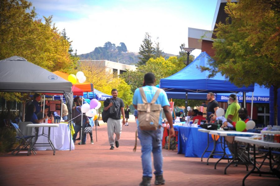 A student walks by booths set up during Comet Cash Day in the Campus Center Plaza on Oct. 3. 