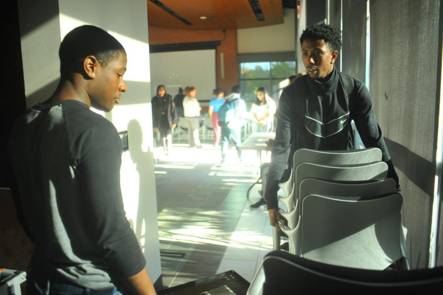 Students put away tables after the student town hall event finished early because of the lack of administrative participation in the Fireside Hall on Thursday.  