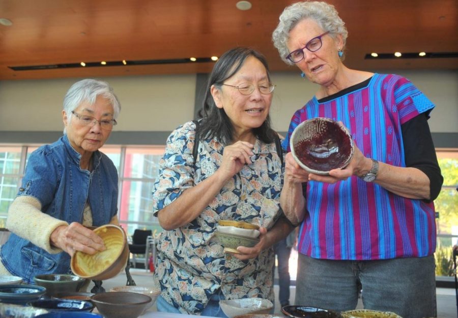 Ceramics instructor Mary Law (right) shows off a ceramic bowl to art majors Barbara Burgess (left) and Grace Brown at Fireside Hall.