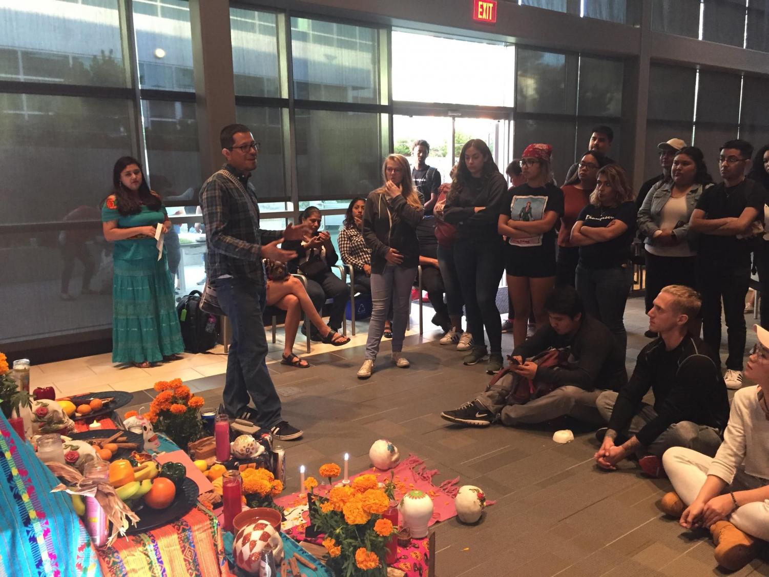 La Raza studies professor Augustin Palacios speaks to the crowd at the Dia de los Muertos event in Fireside Hall on Thursday.