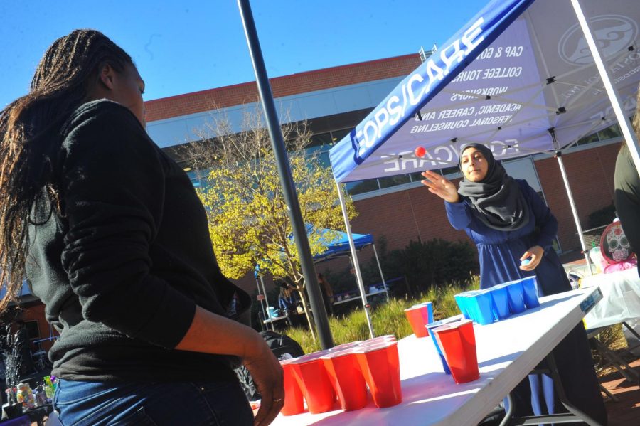 Student Malekah Isa (right) plays soda pong during Club Rush in the Campus Center Plaza on Oct. 31. 