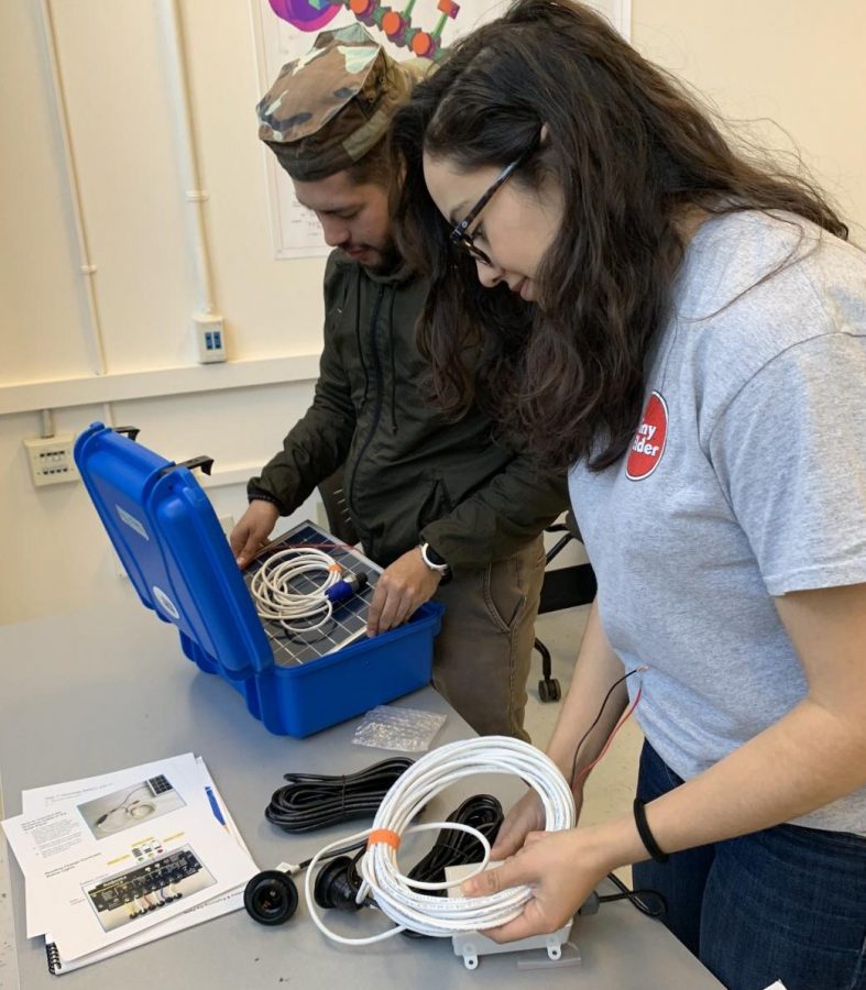 STEM majors Christan Vazquez (left) and Vaness Hernandez test out the solar power suitcase during the Society of Hispanic Professional Engineers meeting on Friday in the Physical Science Building. Prototypes of the suitcases are being built to help third world countries with no electricity.