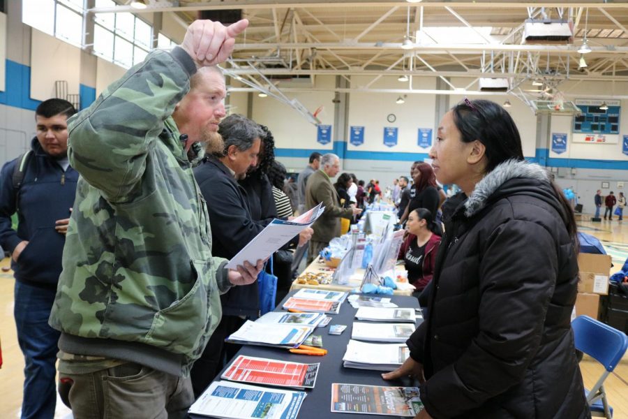 A student (left) talks to CalTrans representative, who refused to give her name, during the West Contra Costa County job fair on March 20 in the Gymnasium. More than 50 employers and 20 resource tables were available for students to explore. 