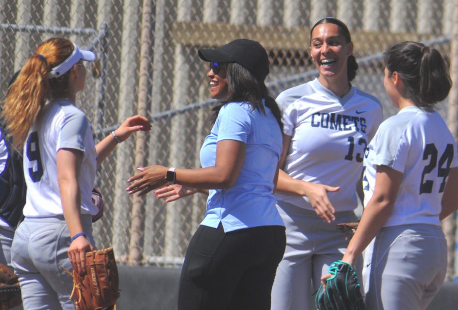 Coach Taylor Harris (middle) has adjusted the way the softball team is coached because of the level the team is at. Harris has coached a seasoned team before, and now takes up the challenge to start off with an inexperienced squad. 