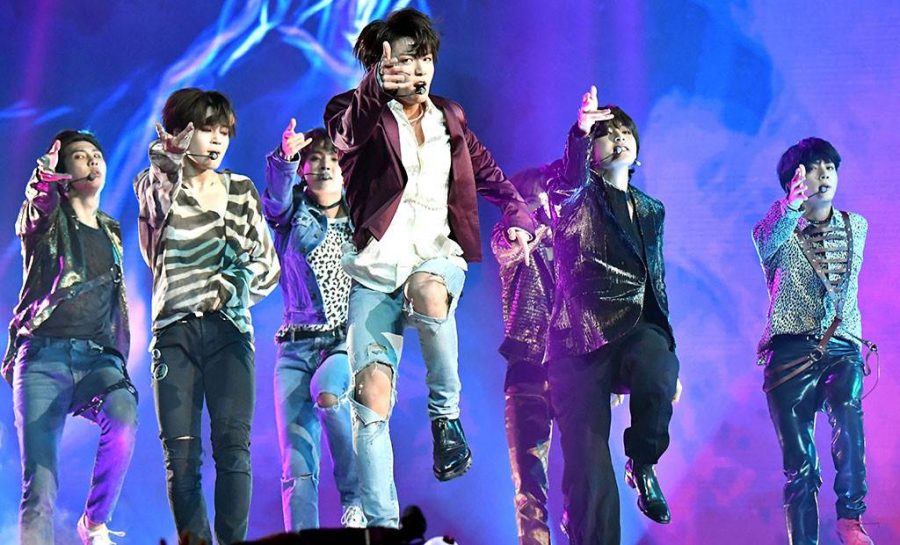 BTS performs a choreographed group dance routine and sings during one of its concerts.