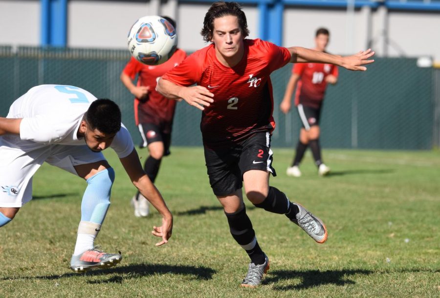 A Las Positas player runs for a bouncing ball as he passes a Comet player during Contra Costa College’s
2-0 loss on Sept. 17 at the Soccer 
Field. 