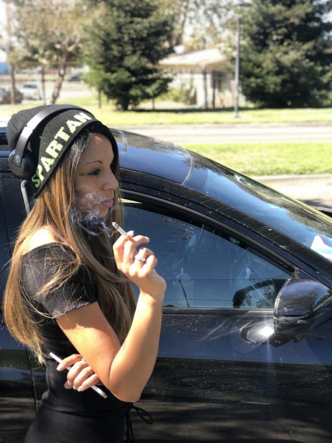 CCC student Daniele Tabor smoking next to her car parked on Campus Drive on Oct. 4 