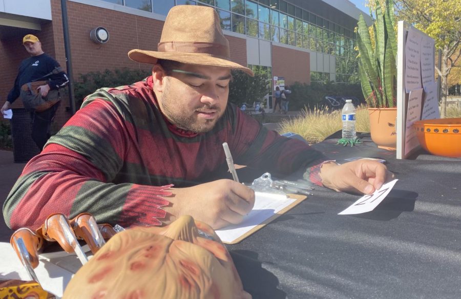 Student Life Coordinator Charles Ramirez assigns numbers to the participants in the Halloween costume contest in the Campus Center Plaza on Oct. 30.