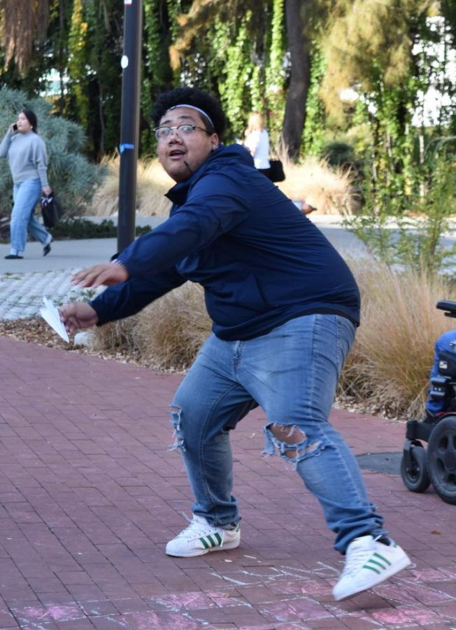 Student Armani Jones prepares to launch his paper airplane during the Fly High competition held in Campus Center Plaza on Nov. 19.