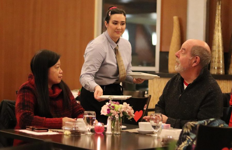 A waiter serves community members Madeleine and James Machado at the Cupid’s Season Dinner Scholarship Event on Friday.