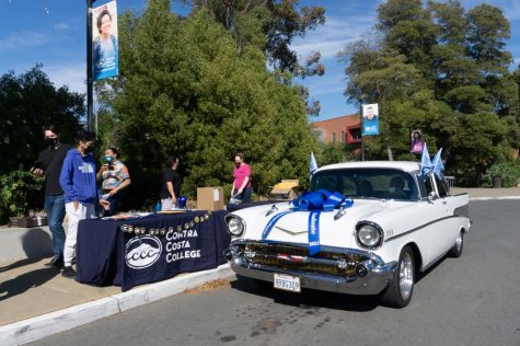On May 6, Honors student Angelina Padilla receives her grad pack at the drop-off zone in her familys 1957 Chevrolet, decorated with flags and a big bow. (From left to right) Larry Womack, David De La Cruz, Jason Cifra, Dennis Franco and Kate Weinstein distribute grad packs to students .