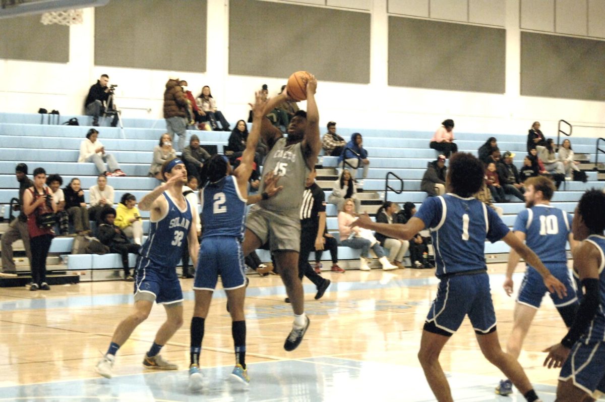 Contra Costa Comet player no#. 15 G, Jelani Clark, rises above the Solano players in scoring another point. 

San Pablo Ca 14 February  2024, Contra Costa College, Men’s Basketball game vs. Solano College