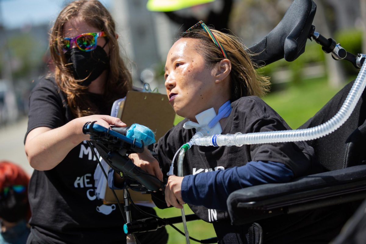 Alice Wong, founder of the Disability Visibility Project, delivers remarks to demonstrators at the Keep Masks in Health Care rally outside City Hall on April 16, 2024, in San Francisco, Calif. 