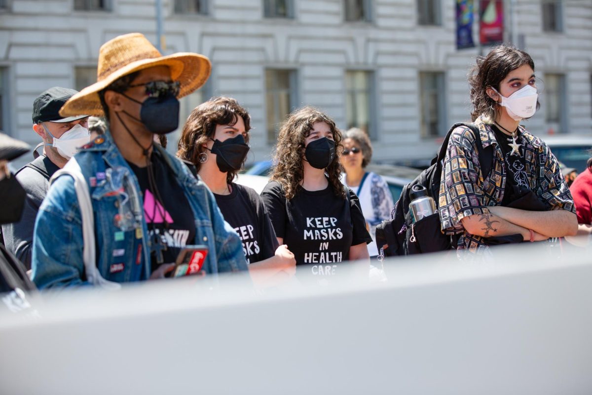 Demonstrators listen to a speech during the Keep Masks in Health Care rally outside San Francisco City Hall, on April 16, 2024 in San Francisco, Calif.