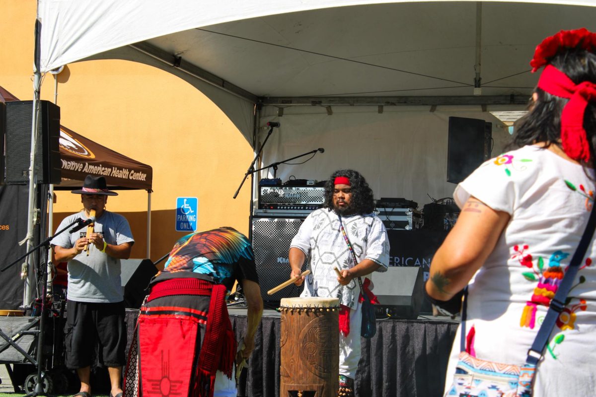 Drummer and Flutist performing while the Calpulli Coatlicue dance at the Indigenous Red Market in Derby Ave. in Oakland, Calif., on Oct. 6,2024