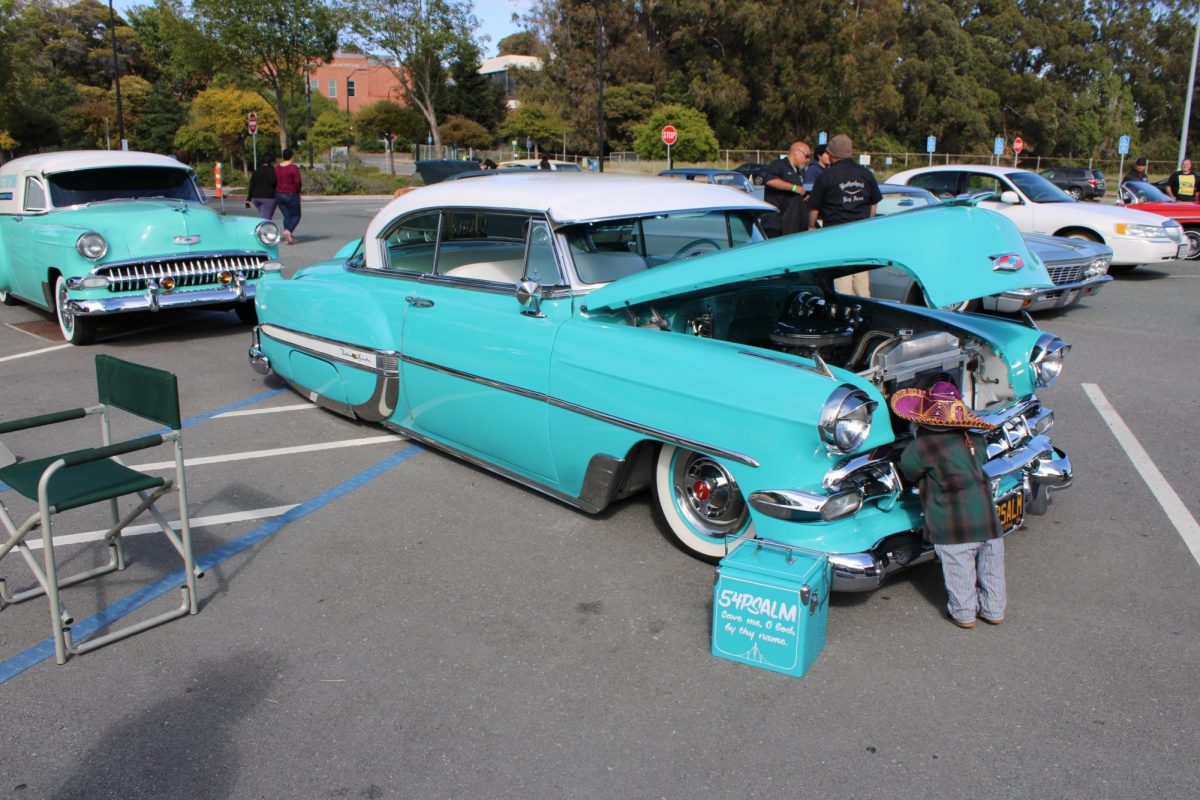  1970 teal Chevy belair with doll sticking out of it 