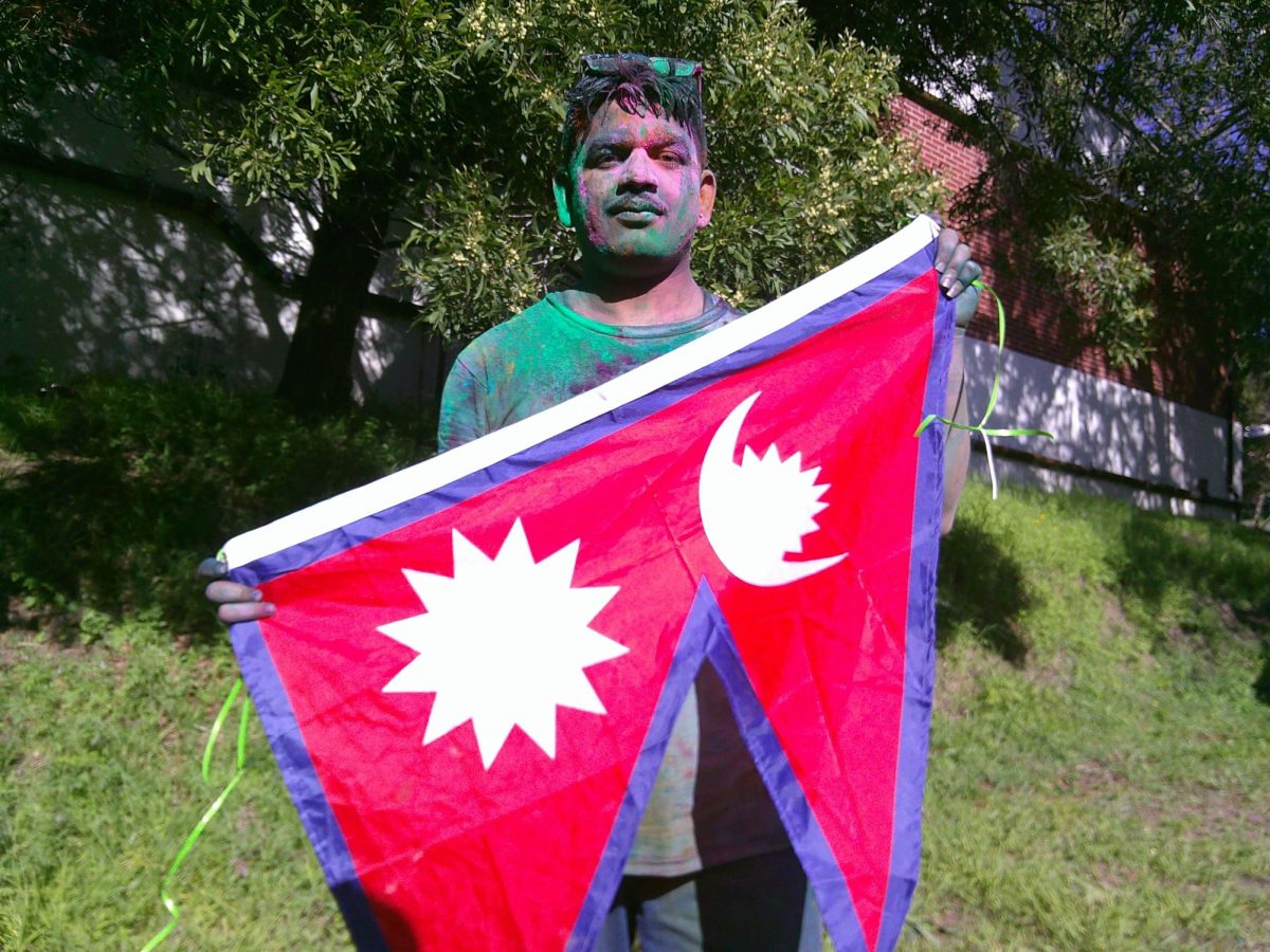 Anova Singh Thakur, vice president of the International Student Club at Contra Costa College, poses with a flag from Nepal at the club's Holi Festival celebration on March 4, 2026 in San Pablo, Calif. (Leon Watkins/The Advocate)
