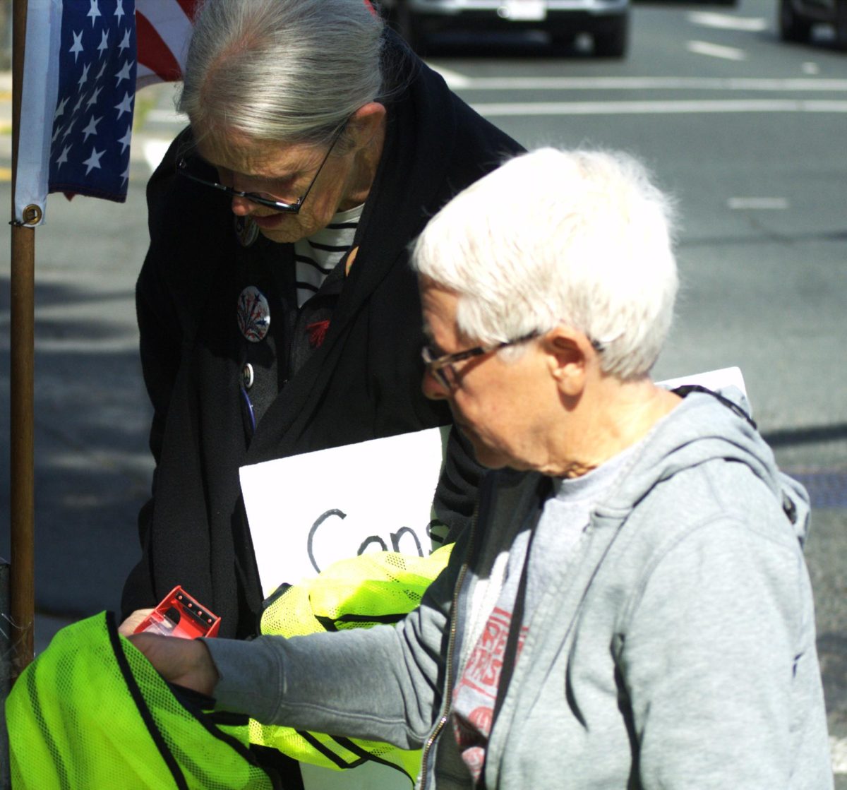 Nancy Burke, one of the coordinators of a May Day rally, works with an organizer at the demonstration along San Pablo Dam Road and Appian Way in El Sobrante, Calif., on Friday, May 1, 2026. (Leon Watkins/The Advocate)